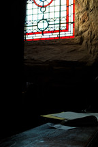light from a stain glass window shining on a hymnal