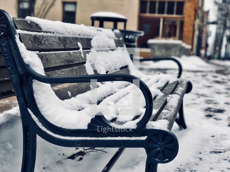 snow on a park bench 