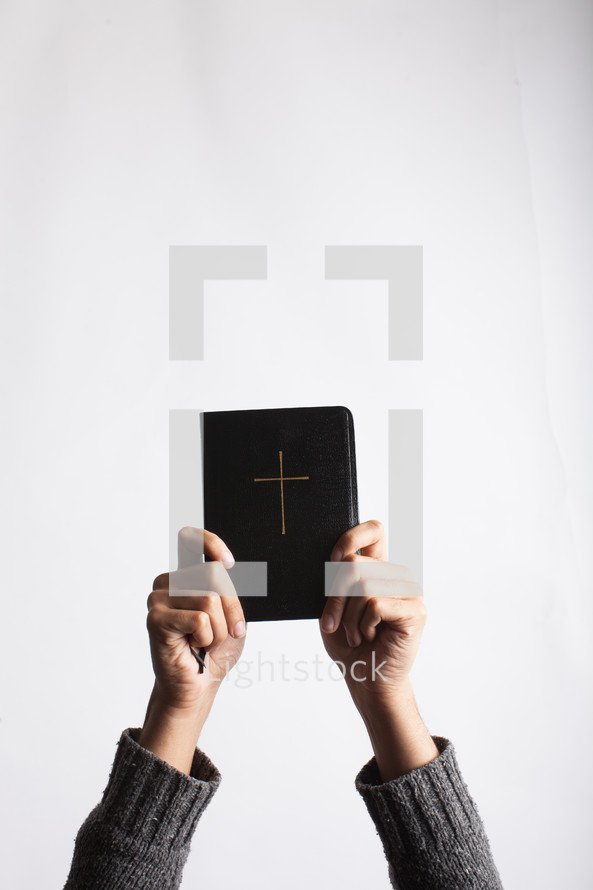 a woman holding up a Bible 
