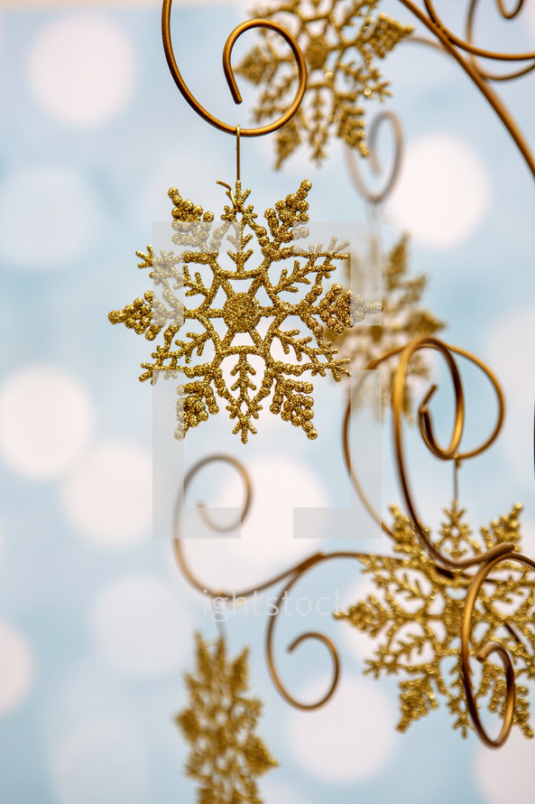 Gold, glittery snowflake decoration on blue background