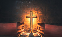 glowing cross between two Bibles 