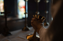 Hand holding a communion chalice.