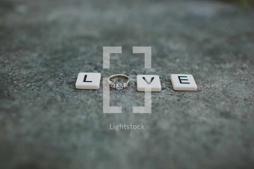 word Love - scrabble pieces and and engagement ring