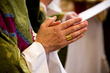 hands of a priest in prayer 