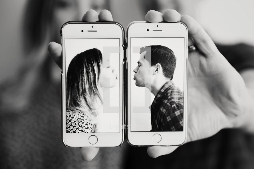 couple kissing on cellphones 