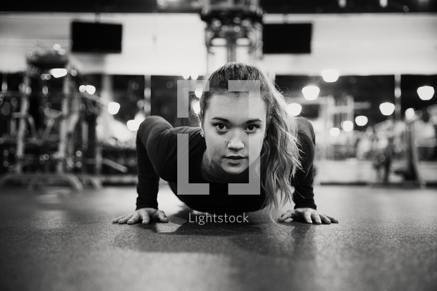 woman doing pushups in a gym.