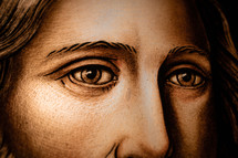 Close up of a stained glass window of Jesus's eyes looking with compassion.