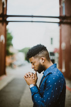 a man praying in an alley 