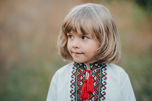 Portrait of handsome ukrainian boy in apple orchard. Child in traditional embroidery vyshyvanka shirt. Ukraine, freedom, national costume. High quality photo