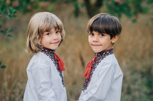 Portrait of handsome ukrainian boys in apple orchard. Children in traditional embroidery vyshyvanka shirts. Ukraine, freedom, national costume. High quality photo