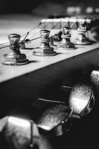 Close up from an old vintage guitar headstock , Full with dust. In black and white.