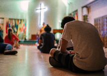 teens sitting on the floor during a worship service 
