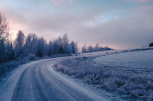 winter scene on a snowy field and dirt road 