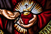 Stained glass window of flaming sacred heart.