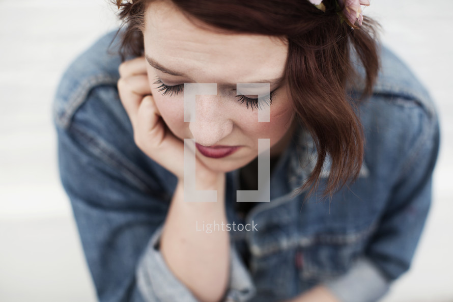 A sad young woman looking down.