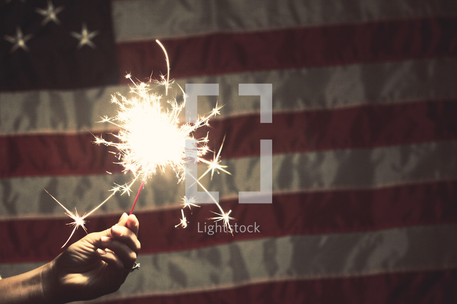 sparkler in front of an American Flag