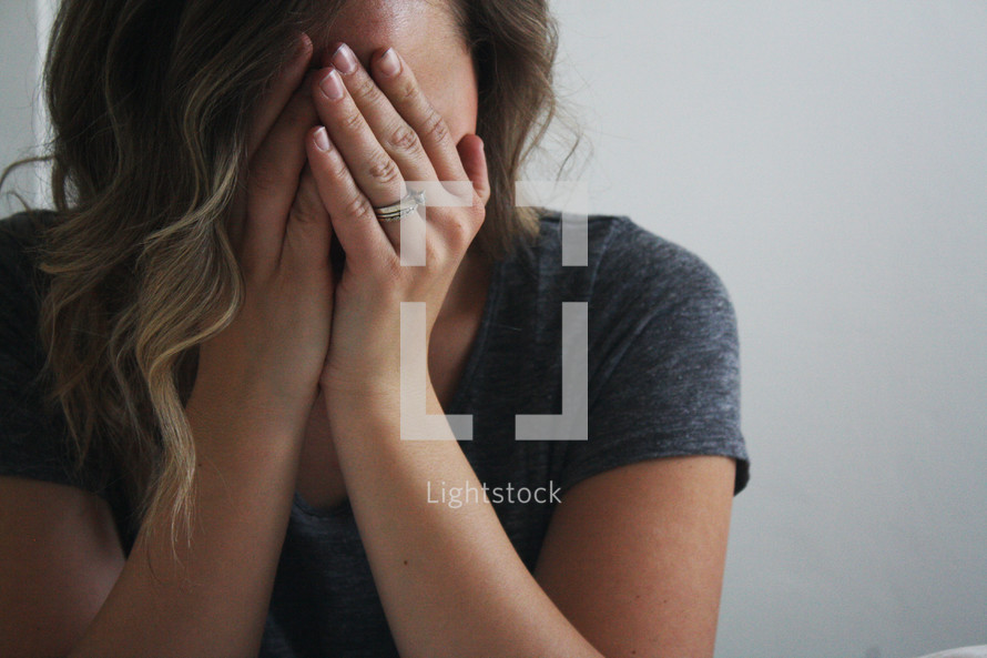 woman covering her face with her hands 