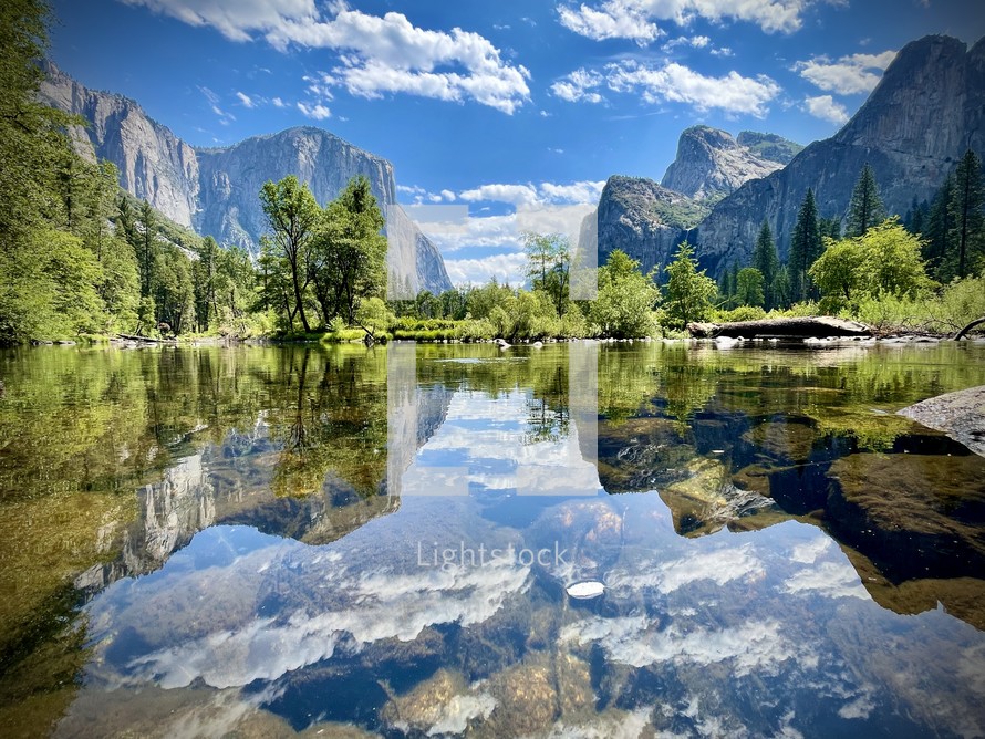 reflection of mountain cliffs in a calm river 
