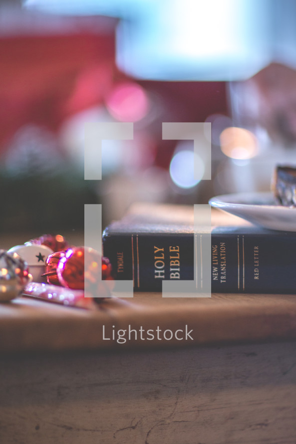 a Bible on a table next to Christmas decorations 