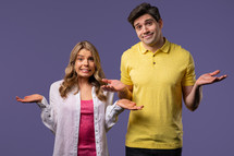 Confused man woman, couple shoulders up - can't help, makes gesture of dont know