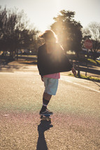 a teen girl skateboarding at sunset 