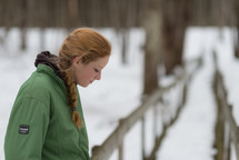 a teen girl standing outdoors in a winter coat 