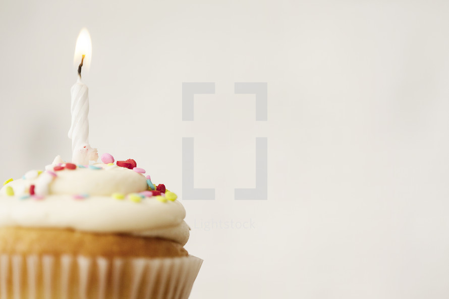 cupcake and candles against a white background 