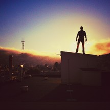 Man on rooftop at sunset