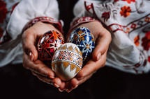 Ukrainian woman hand painted Easter eggs. Beautiful geometric slavic decoration. Lady in embroidery vyshyvanka dress. High quality photo