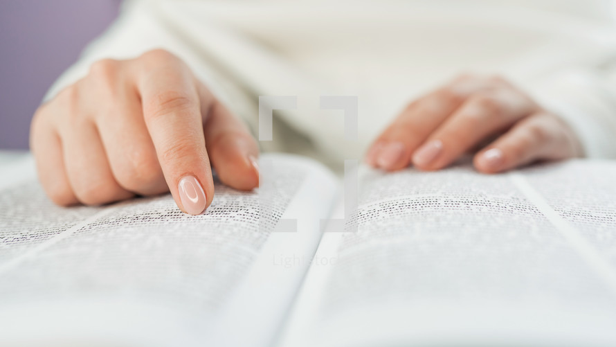 Unrecognizable woman reading Holy Bible