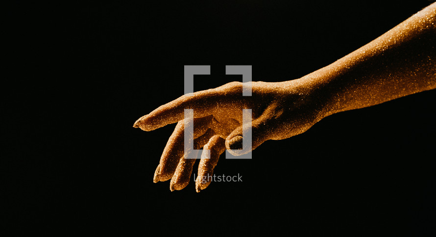 Golden glittering woman hand with dust or sand on black background. Shimmer, time, life moments, deadline, business management, educational creative content concept.