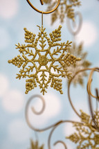 Gold, glittery snowflake on blue background