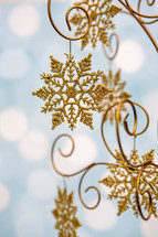 Gold, glittery snowflake decoration on blue background