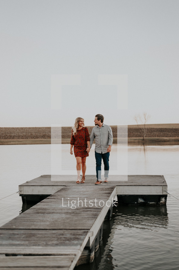 couple on a dock holding hands 