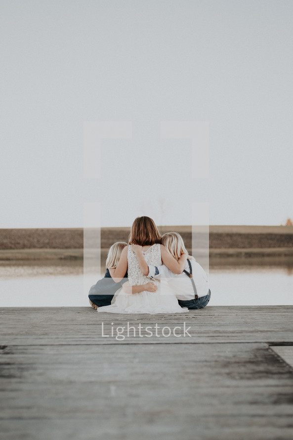 siblings sitting on a dock 