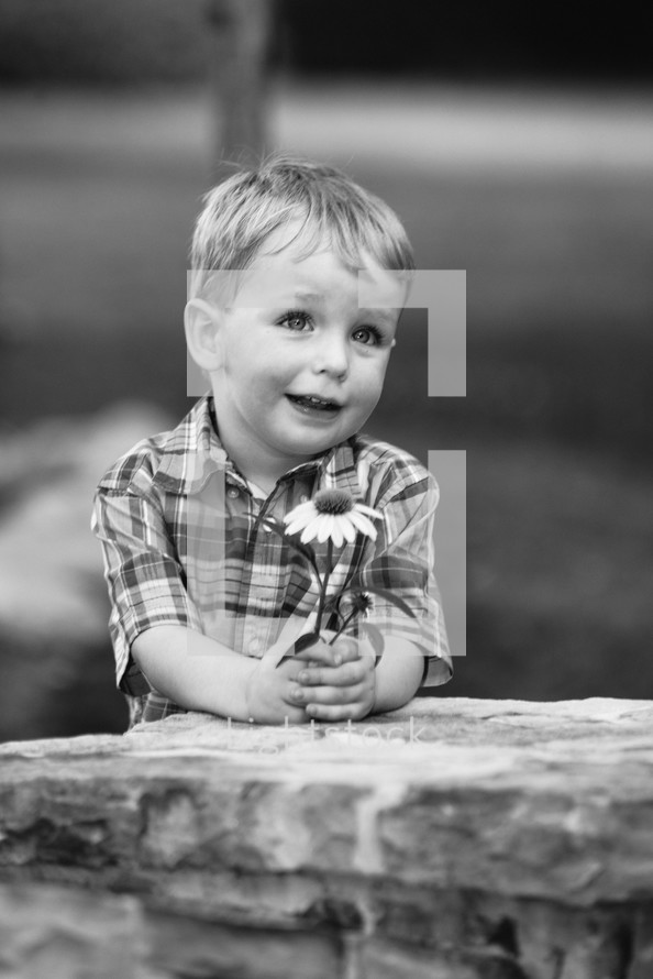 a boy child holding a flower 