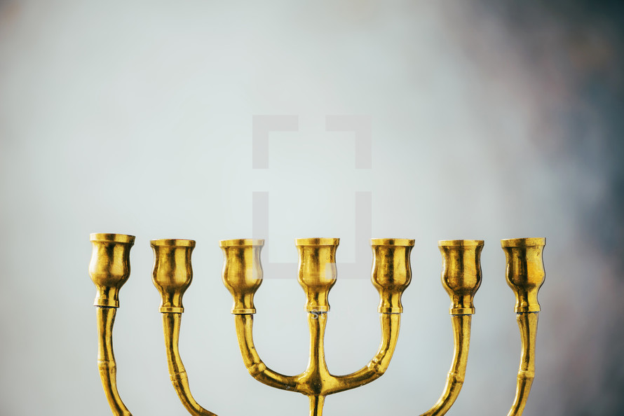 Golden hanukkah menorah on grey background. Jewish holiday banner with copy space. Ancient ritual religious candle menorah