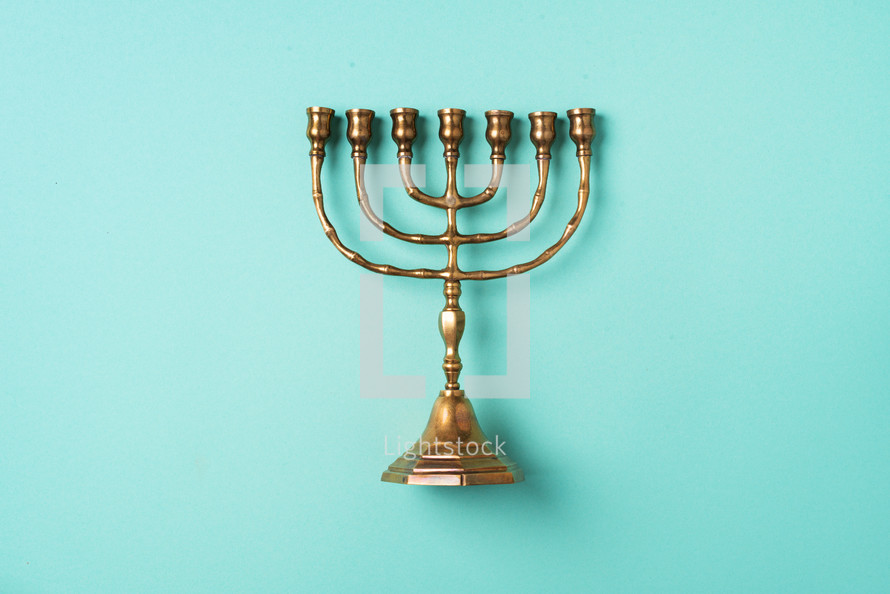 Golden hanukkah menorah on blue background. Jewish holiday banner with copy space. Ancient ritual religious candle menorah