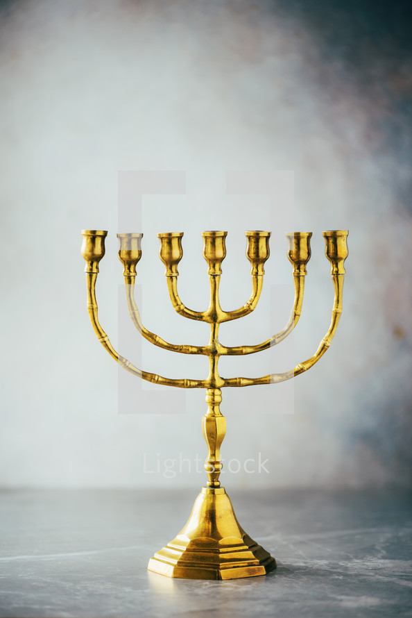 Golden hanukkah menorah on grey background. Jewish holiday banner with copy space. Ancient ritual religious candle menorah