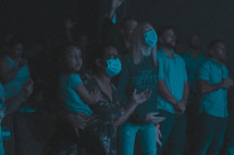 congregation in face masks singing during a worship service 