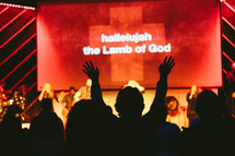 silhouette of raised hands at a contemporary worship service 