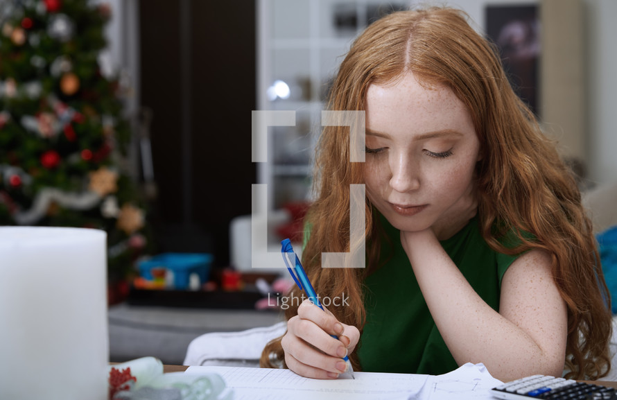 girl doing homework at Christmas 