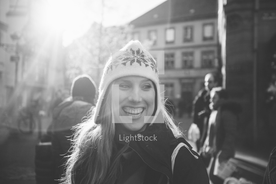 face of a smiling woman standing in a courtyard in winter 