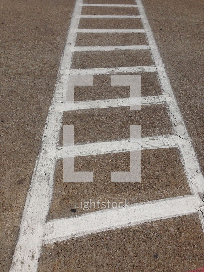 white lines delineate a crosswalk, ladder-like effect