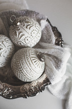 Silver and White Christmas Ornaments in a Silver Bowl on White Background