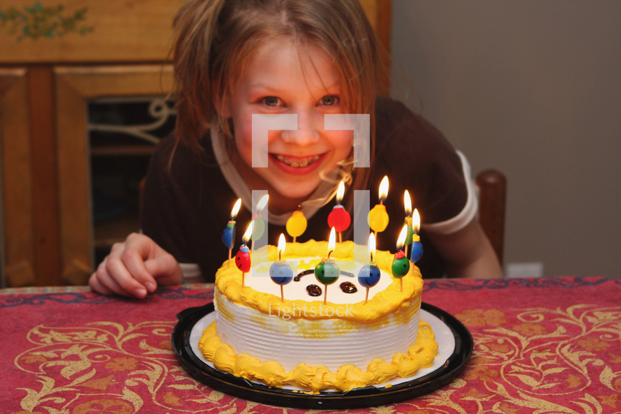 a young girl with the joy of her birthday cake and candles