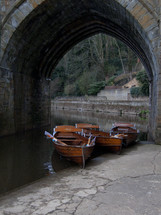 paddle boats in water under a bridge 
