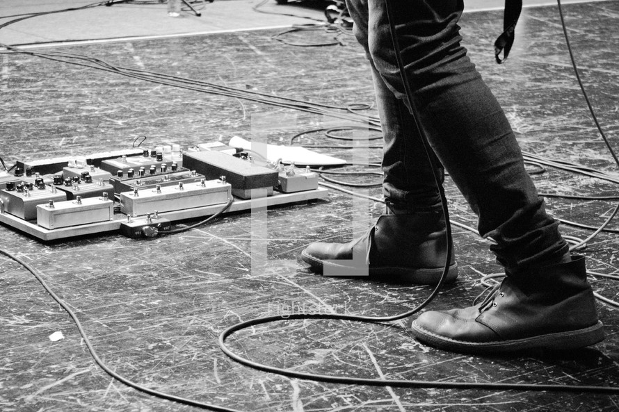 A man' foot near guitar pedals. 