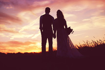 silhouettes of a bride and groom at sunset 