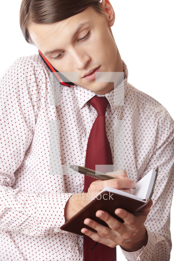 businessman taking notes talking on a phone 